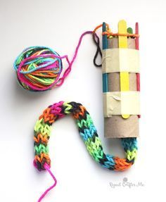 a roll of yarn next to a crochet loom and ball of yarn