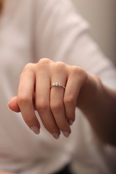 a woman's hand with a diamond ring on it