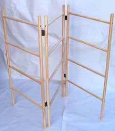 two wooden ladders are standing next to each other on a white background in front of a plain backdrop