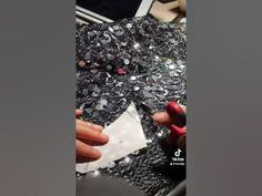 the woman is cutting up silver sequins with scissors