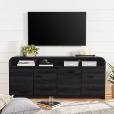 a flat screen tv mounted to the side of a wooden entertainment center