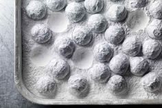 a pan filled with powdered donuts on top of a table