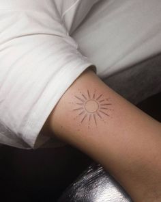 a person with a small sun tattoo on their arm