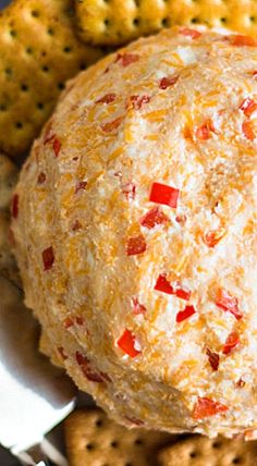 cheese ball with pepperoni and crackers on the side, ready to be eaten