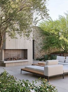 an outdoor living area with couches and a fire place