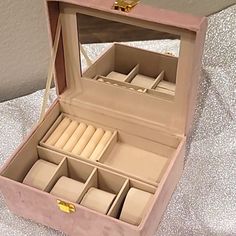 an open pink box with many compartments on it