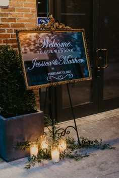 a sign with candles in front of it that says welcome to our wedding