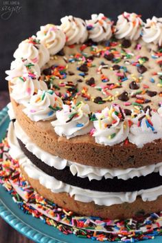 a chocolate cake with white frosting and sprinkles on top is shown