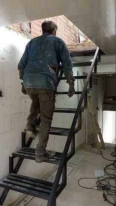 a man is climbing up the stairs in an unfinished building