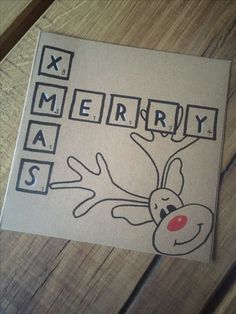 a piece of paper with the words merry and reindeer drawn on it sitting on a wooden table