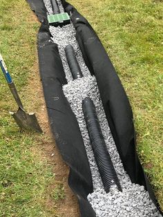 an inflatable boat is laying on the ground next to a shovel and some gravel