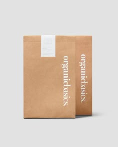 two brown paper bags with white lettering on the front and back, one is empty