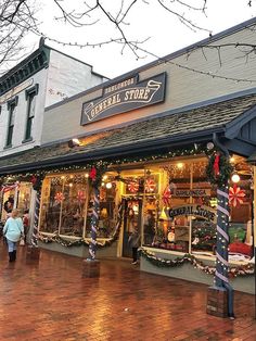 people are walking in front of a store decorated for christmas