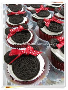 cupcakes decorated like minnie mouse ears with red bows and oreo cookies on them