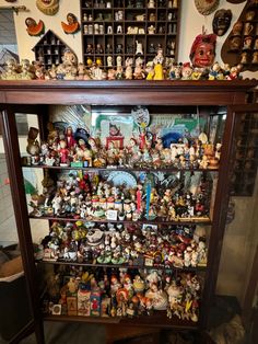 a display case filled with lots of different types of figurines on top of shelves