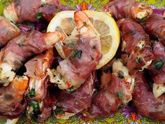 a plate full of shrimp and lemons on top of a table with a floral design