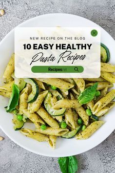 pasta with zucchini and pesto sauce in a white bowl on top of a table