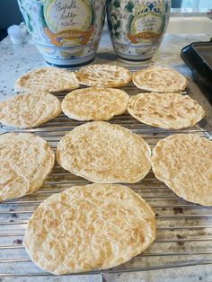 several tortillas cooling on a rack in front of two cans of coffee and an egg shaker