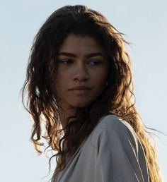 a close up of a person with long hair and blue eyes looking at the camera