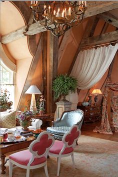 a living room filled with furniture and a chandelier hanging over the top of it