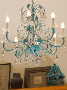 a blue chandelier hanging from the ceiling in a room with pictures on it