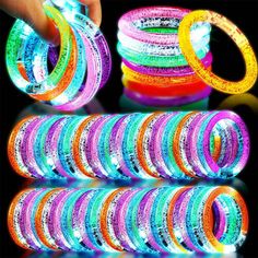 glow bracelets are stacked on top of each other, with one being held in the air