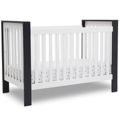 a small white crib with black trim