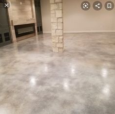 an empty room with a fireplace in the center and no one around it on the floor