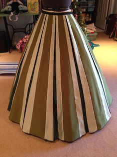 a dress on display in a room with a christmas tree and other items behind it