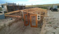 an unfinished building with wooden framing and windows on the roof is being worked on by construction workers