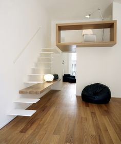 a living room with white walls and wooden floors