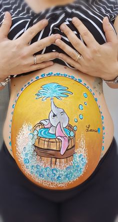 a pregnant woman's stomach with an elephant painted on the side and under her belly