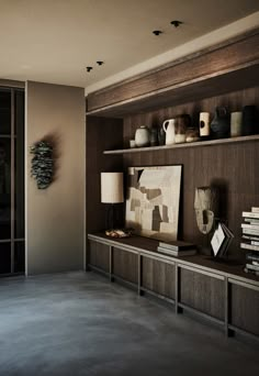 a shelf with vases and other items on top of it in a living room