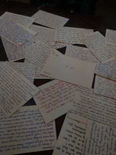 many pieces of paper with writing on them sitting on a table next to each other