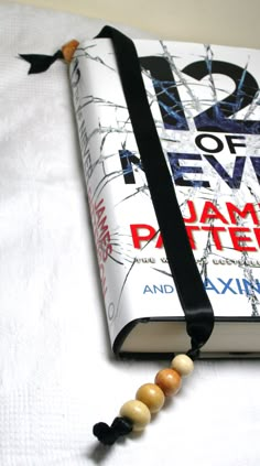 a book with beads on it sitting on top of a white cloth covered tablecloth