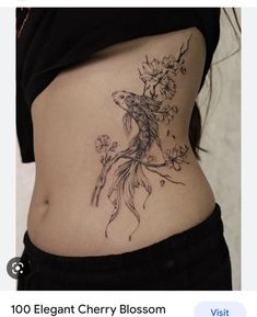 a woman's stomach with a flower tattoo on her lower back and the words, 100 elegant cherry blossom tattoos