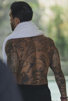 a man with tattoos on his back walking