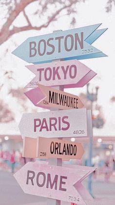 a street sign with many different colored signs on it's sides and the words boston, tokyo, milwaukke, paris, or roma