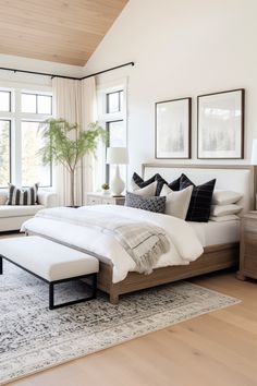 a large white bed sitting in a bedroom next to a window filled with lots of windows