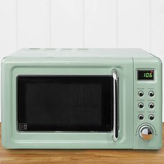 a white microwave oven sitting on top of a wooden table