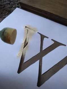 a piece of wood that has been cut into the shape of a letter with scissors