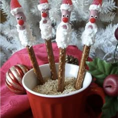 some pretzels with santa hats on them in a cup