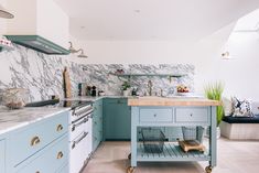 a kitchen with blue cabinets and marble counter tops