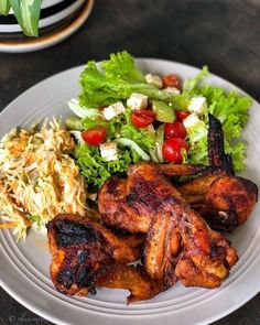 a white plate topped with chicken and salad