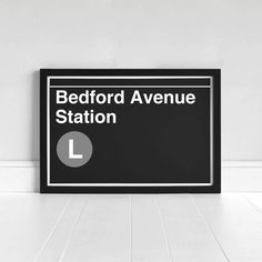 a black and white sign that says bedford avenue station on the side of a wall