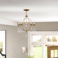 a chandelier hanging from the ceiling in a room with white walls and windows