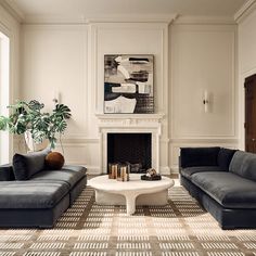 a living room with two couches and a coffee table in front of a fireplace