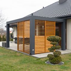 a modern house with wooden slats on the front and side walls, surrounded by green grass