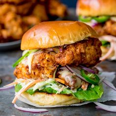 a chicken sandwich with lettuce and onions