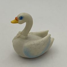 a white duck with blue eyes sitting on top of a table